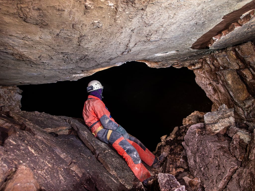 Overlooking the vast darkness. Mike is looking into Zvijerko, a 200 m (600 feet) deep shaft. Montenegro. Photo: Katarina Kosič Ficco