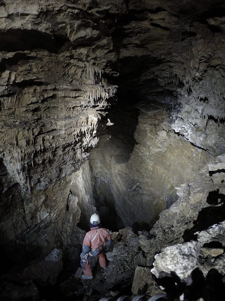 Mike Ficco overlooking 99 Luftballons cannyon in Vručični Snovi Cave, discovered in 2023 by TLA. The air blowing in your face from the cannyon gives you the feeling of a ballon in the wind. Photo: Katarina Kosič Ficco