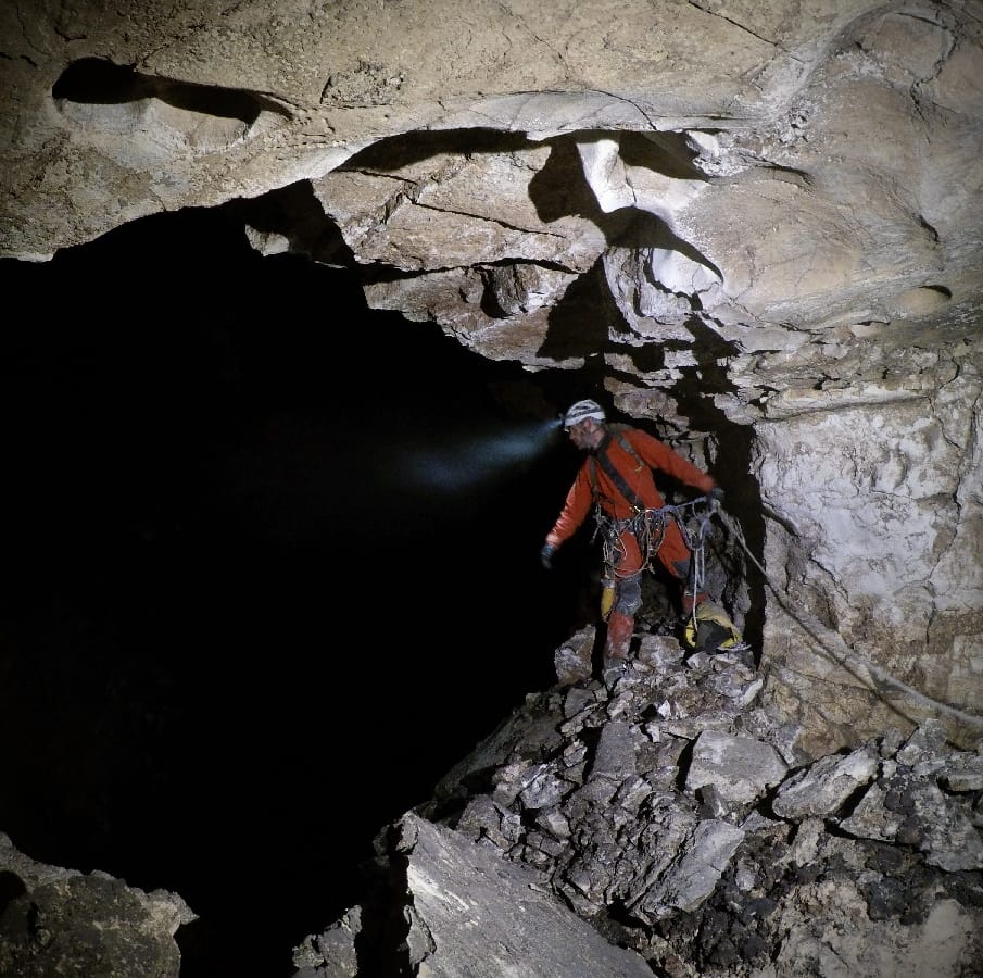 Jeff Wade, at the edge of the Zvijerko shaft, is trying to assess the pit's depth and riggin potential—a 200 m (600 feet) shaft discovered in 2023 by TLA. Photo: Philip Schuchardt